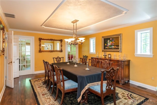 dining area with a raised ceiling, crown molding, dark hardwood / wood-style floors, and a notable chandelier