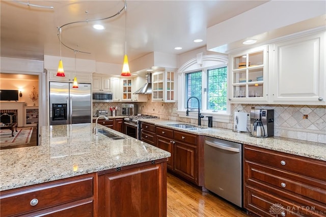 kitchen with white cabinetry, sink, stainless steel appliances, and decorative light fixtures