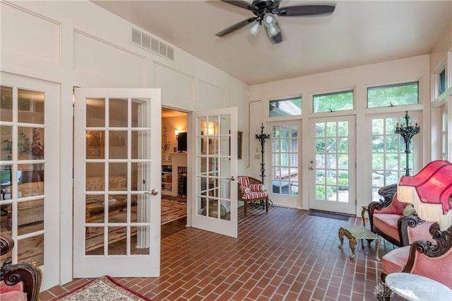 sunroom / solarium with ceiling fan and french doors