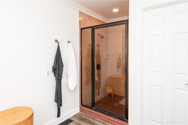 bathroom featuring hardwood / wood-style floors, an enclosed shower, and ornamental molding