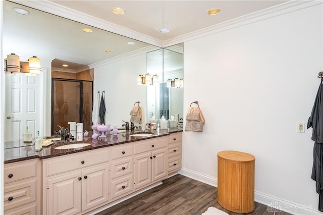 bathroom with hardwood / wood-style floors, vanity, a shower with shower door, and ornamental molding