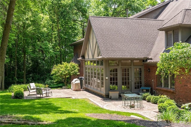 back of property with a yard, french doors, and a patio