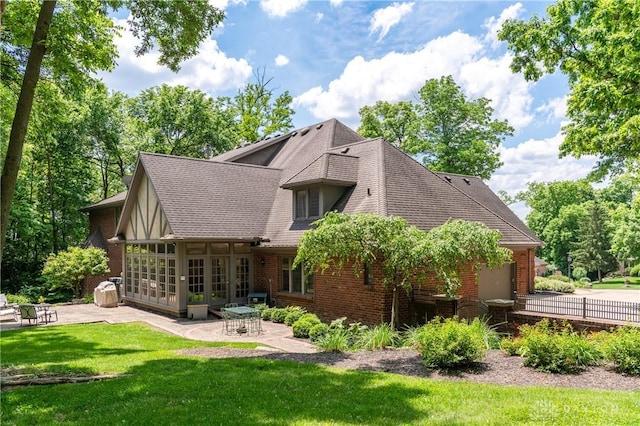 rear view of property featuring a patio area and a lawn