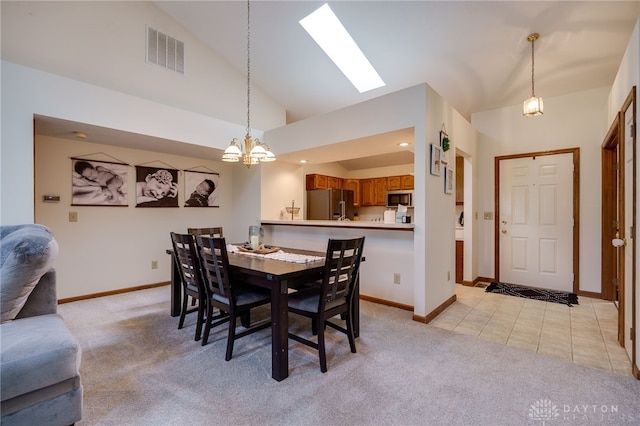 dining space with an inviting chandelier, vaulted ceiling, and light tile patterned flooring