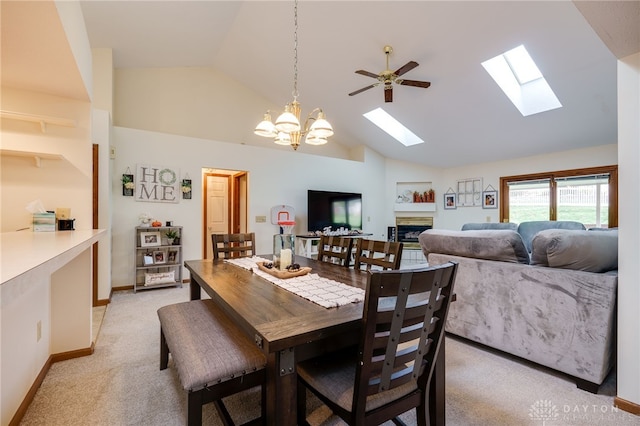 dining room with light colored carpet, high vaulted ceiling, and ceiling fan with notable chandelier