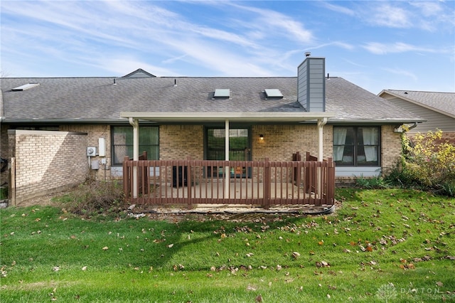 back of property with a deck and a lawn