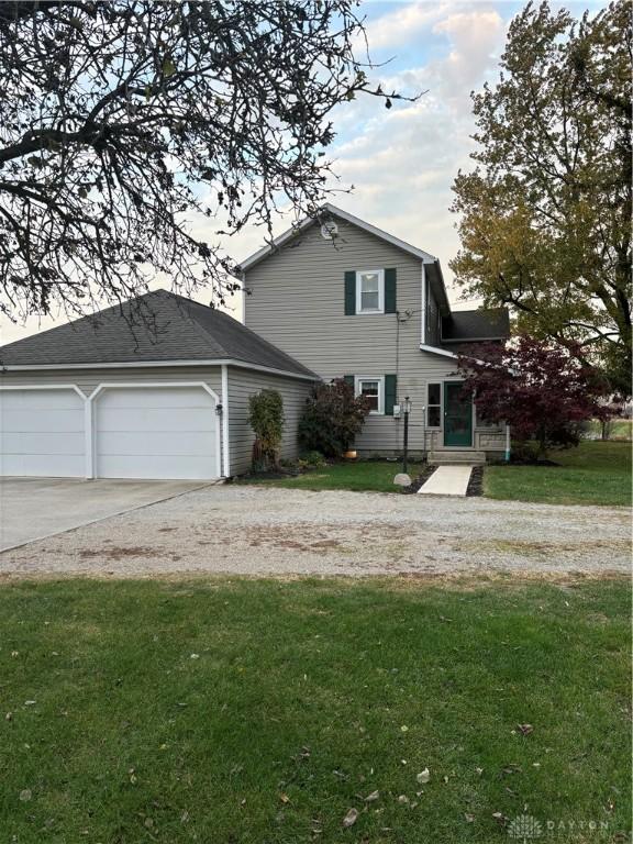 back of property featuring a lawn and a garage