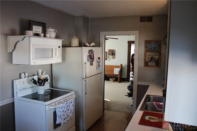 kitchen with white cabinetry, sink, dark hardwood / wood-style floors, and white appliances