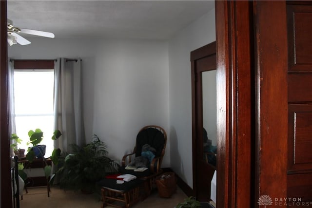 interior space featuring light colored carpet and ceiling fan