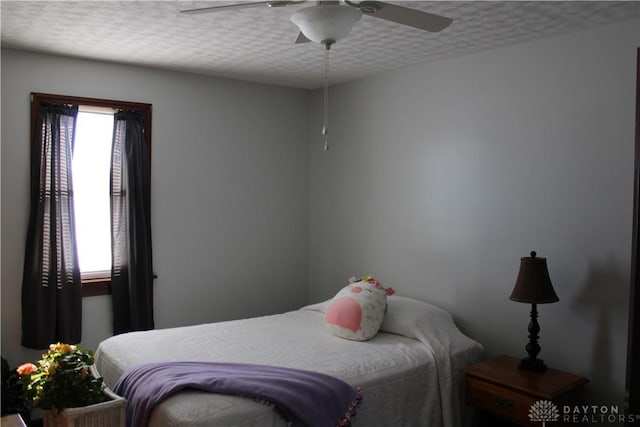 bedroom featuring ceiling fan and a textured ceiling