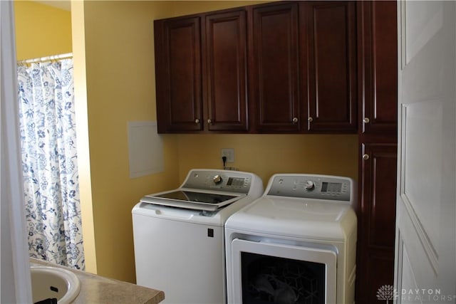 laundry area with cabinets, independent washer and dryer, and sink