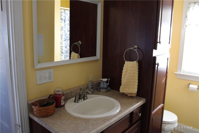 bathroom with plenty of natural light, vanity, and toilet