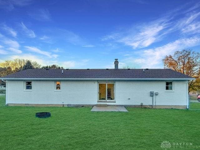 rear view of house featuring a yard and a patio