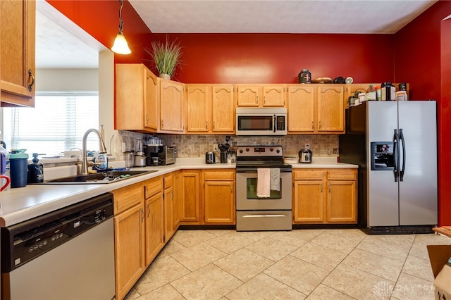 kitchen with pendant lighting, backsplash, sink, and stainless steel appliances