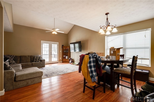 dining area featuring hardwood / wood-style floors, lofted ceiling, and a textured ceiling