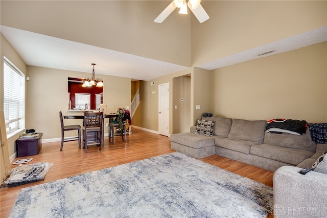 living room featuring wood-type flooring and ceiling fan with notable chandelier