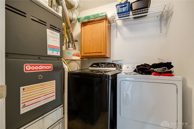 washroom with washer and clothes dryer, cabinets, and heating unit