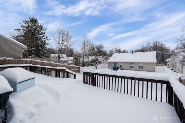 yard covered in snow with a deck