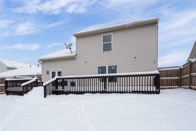 snow covered property with a deck