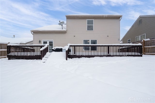 snow covered rear of property with a deck