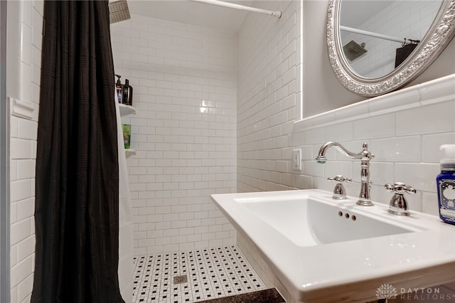 bathroom featuring a shower with shower curtain, sink, and tile walls