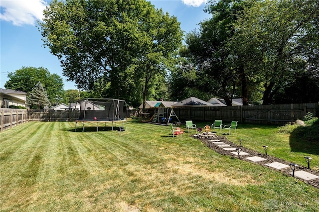 view of yard with a trampoline and a playground