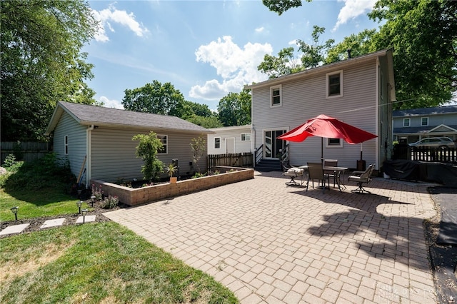 back of house featuring a patio area and a lawn