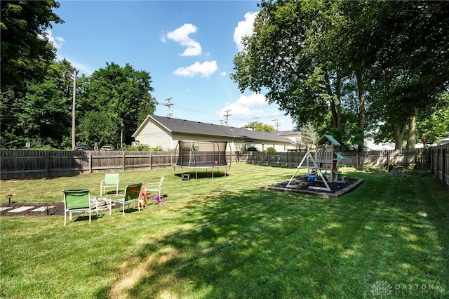 view of yard with a trampoline and a playground