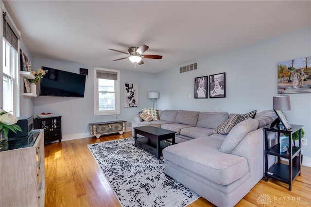 living room featuring light hardwood / wood-style flooring and ceiling fan