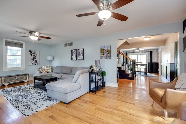 living room with ceiling fan and light wood-type flooring