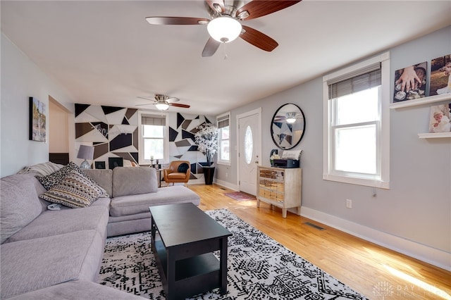 living room featuring light hardwood / wood-style flooring and ceiling fan