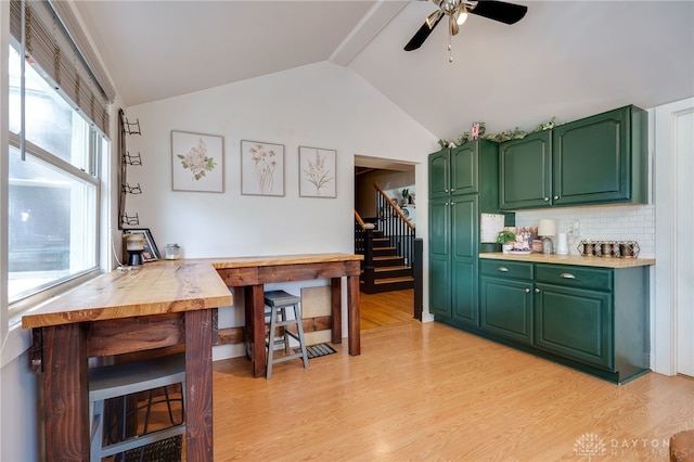 kitchen featuring backsplash, light hardwood / wood-style floors, and green cabinetry