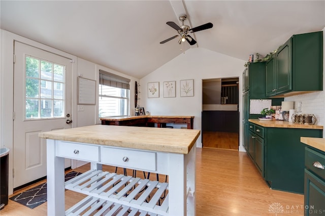 kitchen with ceiling fan, wood counters, green cabinets, light hardwood / wood-style floors, and lofted ceiling