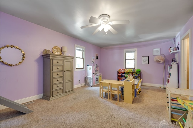 rec room with ceiling fan, a healthy amount of sunlight, and light colored carpet