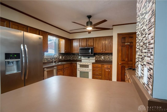 kitchen with appliances with stainless steel finishes, backsplash, ceiling fan, and ornamental molding