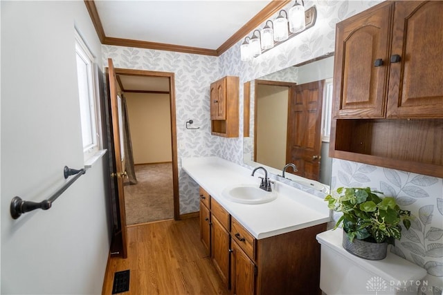 bathroom featuring vanity, hardwood / wood-style flooring, toilet, and ornamental molding