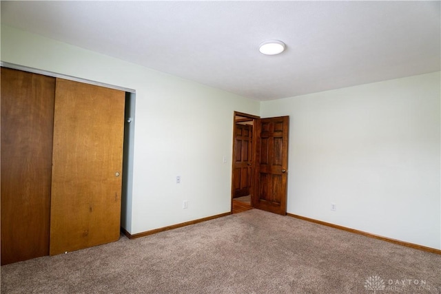 unfurnished bedroom with a closet and carpet flooring