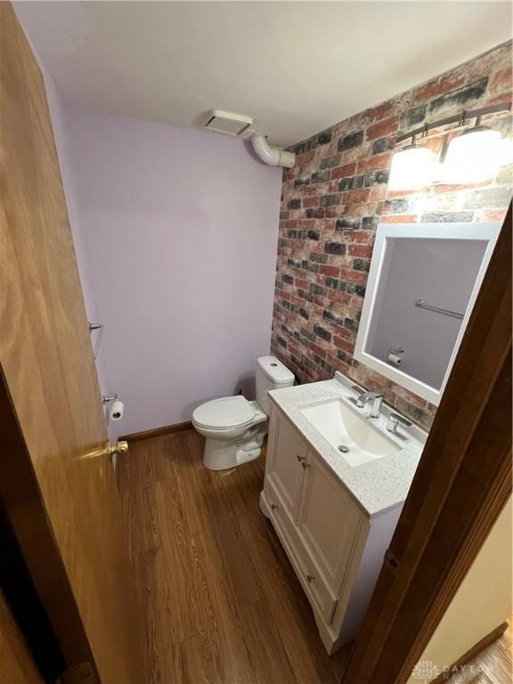 bathroom featuring vanity, wood-type flooring, and toilet