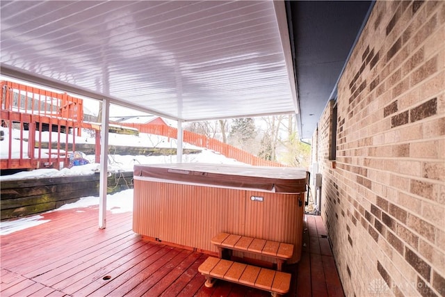 snow covered deck with a hot tub