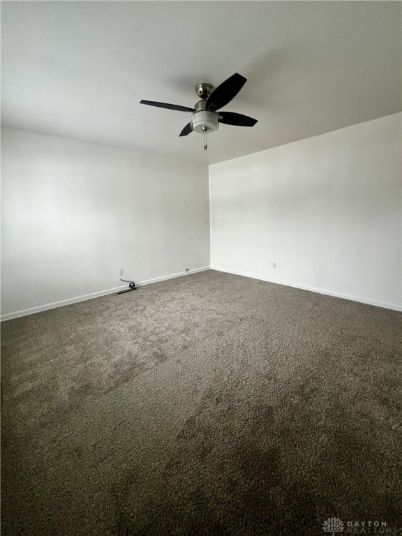 unfurnished room featuring dark colored carpet and ceiling fan