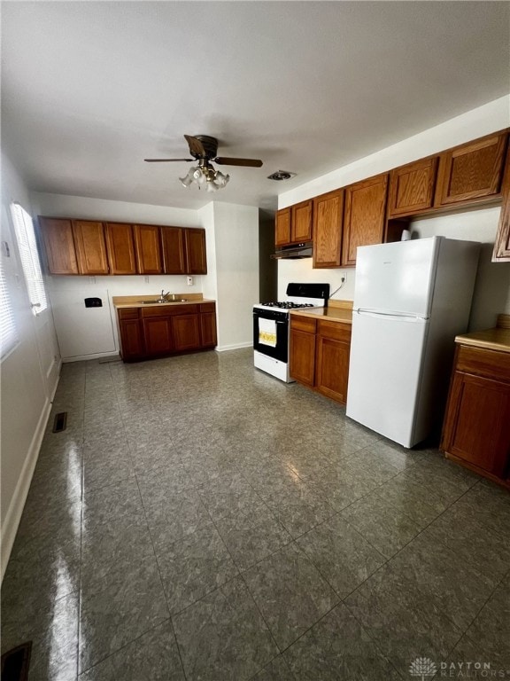 kitchen featuring ceiling fan, sink, and white appliances