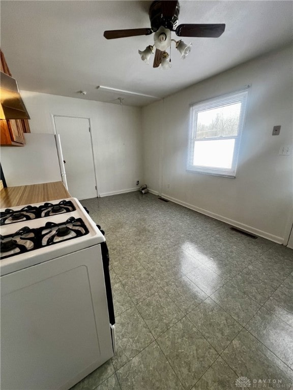 kitchen with island range hood, white gas range, and ceiling fan