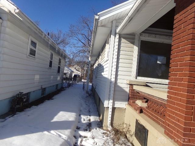 snow covered property featuring brick siding