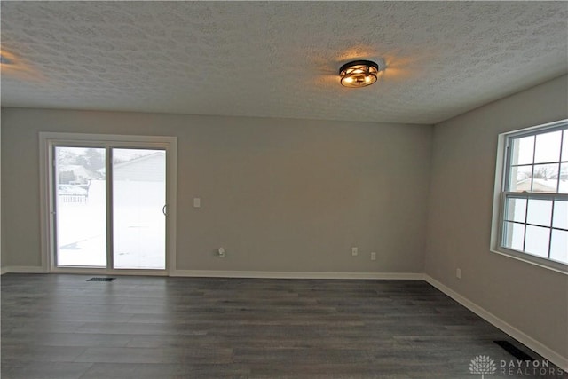 unfurnished room featuring dark hardwood / wood-style flooring and a textured ceiling