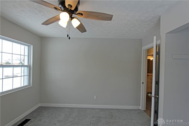 carpeted empty room featuring ceiling fan and a textured ceiling