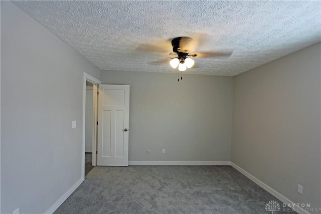 empty room featuring ceiling fan, carpet floors, and a textured ceiling