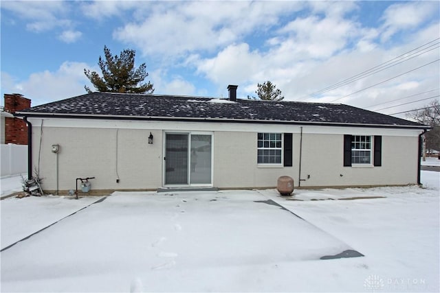 view of snow covered back of property