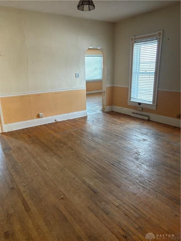 empty room featuring wood-type flooring and a healthy amount of sunlight