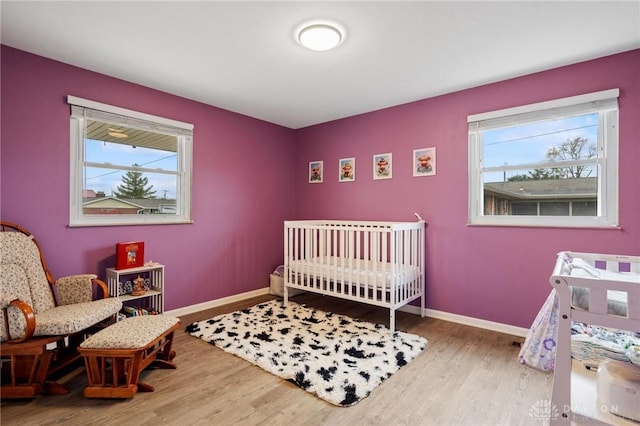 bedroom with hardwood / wood-style flooring and a crib