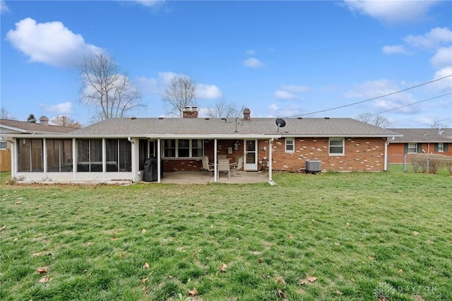 back of house with a sunroom, a patio area, a lawn, and central AC